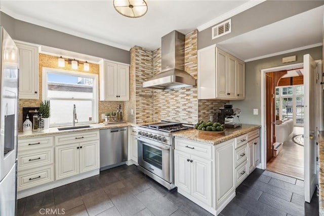 2749 E 17th St, Oakland, CA 94601 - kitchen with wall chimney exhaust hood, stainless steel appliances, light stone counters, decorative backsplash, and ornamental molding
