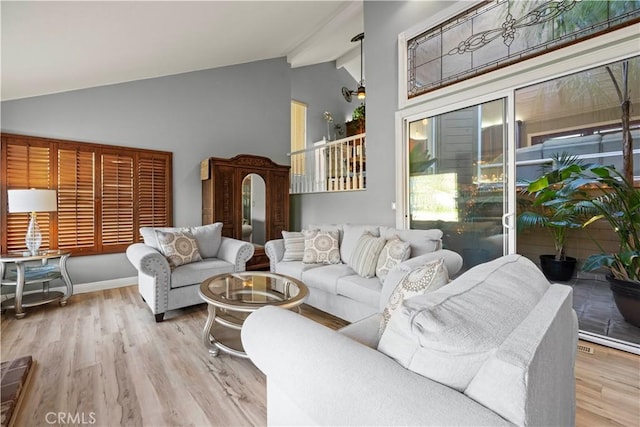 living room with high vaulted ceiling, wood finished floors, and beam ceiling