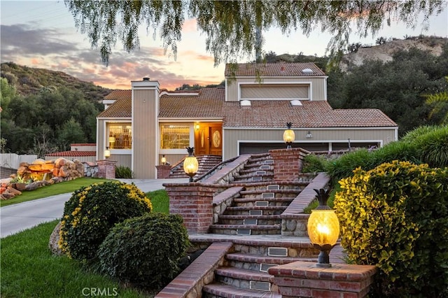 mediterranean / spanish home featuring a tiled roof and stairway