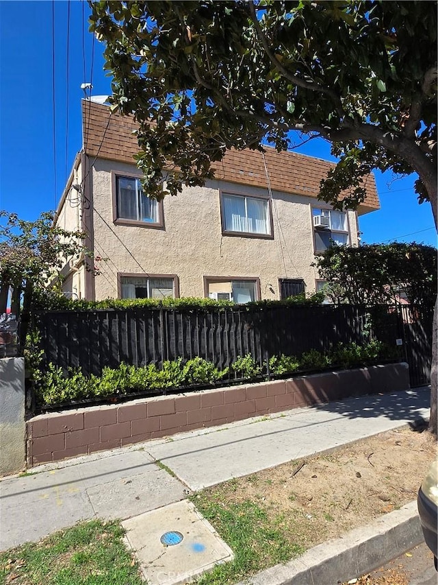 view of property exterior with fence and stucco siding