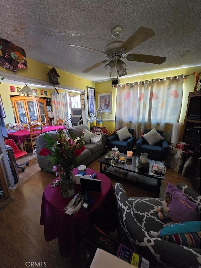 living room with a textured ceiling and a ceiling fan