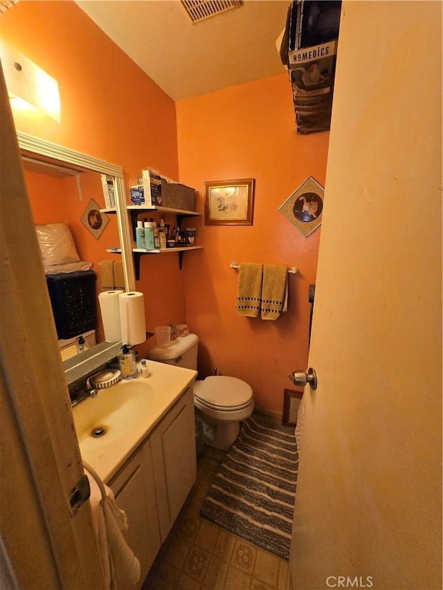 bathroom featuring visible vents, vanity, and toilet