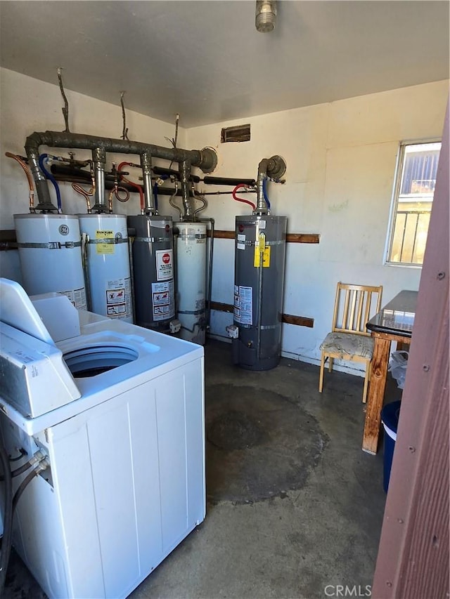 utility room featuring secured water heater, washing machine and clothes dryer, and gas water heater