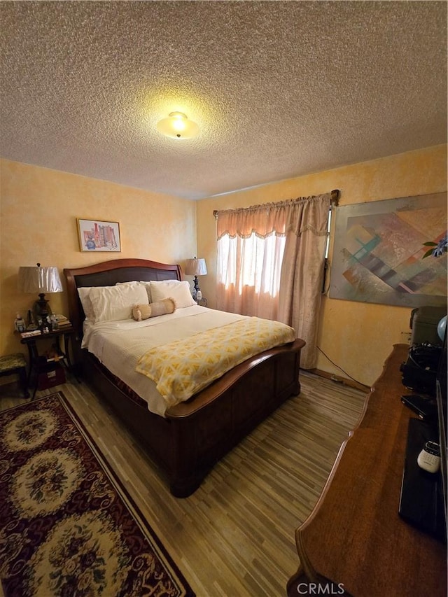 bedroom featuring a textured ceiling and wood finished floors