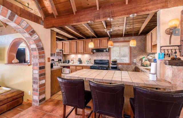 kitchen with tasteful backsplash, wooden ceiling, under cabinet range hood, and black range with gas stovetop