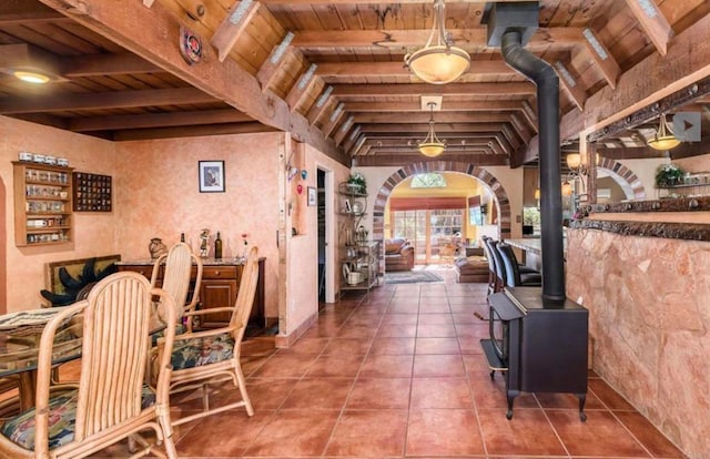 interior space with tile patterned flooring, wood ceiling, vaulted ceiling with beams, and arched walkways