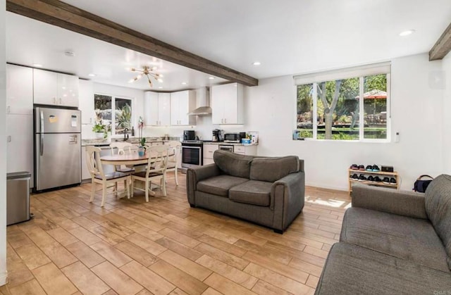 living room featuring light wood-style flooring, a chandelier, beamed ceiling, and recessed lighting