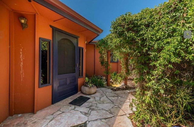 entrance to property featuring a patio