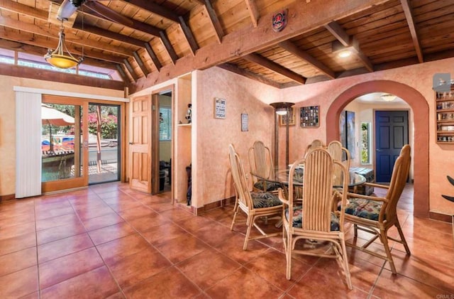 dining room featuring arched walkways, wooden ceiling, tile patterned floors, vaulted ceiling with beams, and french doors