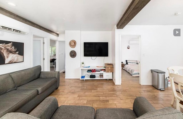 living room featuring a wall mounted air conditioner, beamed ceiling, baseboards, and wood finished floors