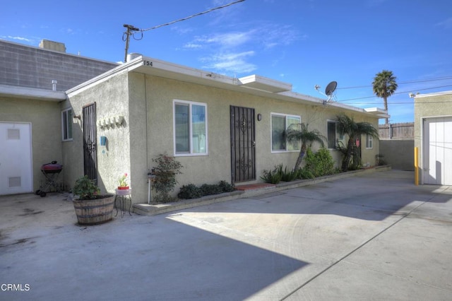 view of front facade with fence and stucco siding