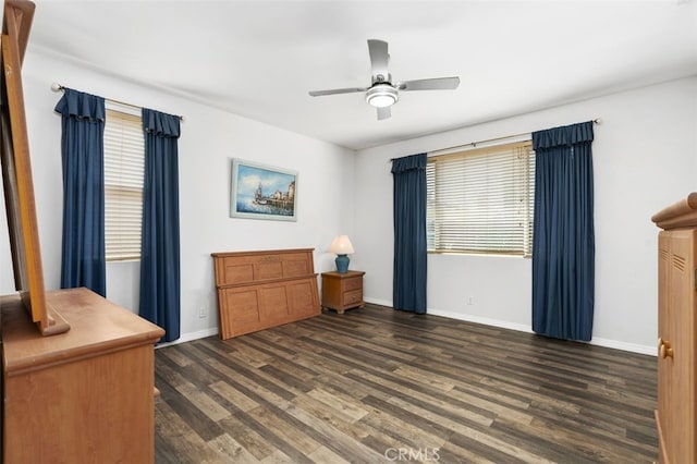 bedroom with ceiling fan, dark wood-type flooring, and baseboards