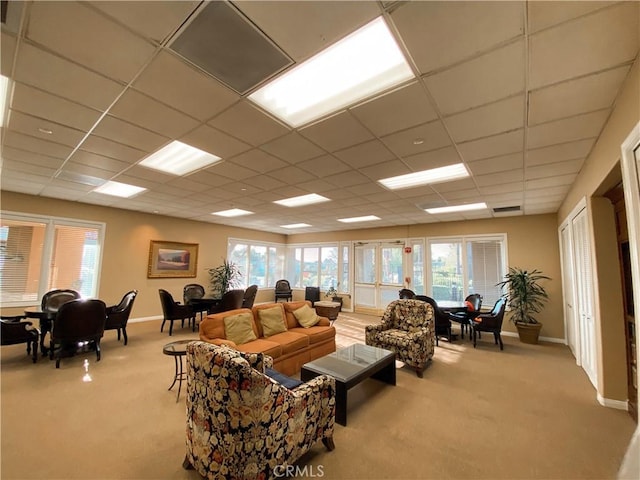 living room with light carpet, a wealth of natural light, and a paneled ceiling