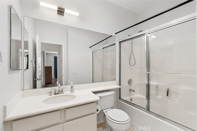 bathroom with toilet, shower / bath combination with glass door, and vanity