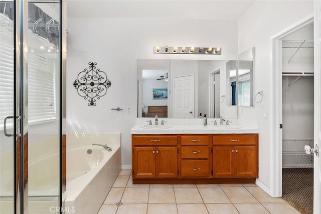 bathroom featuring a bath, a sink, and tile patterned floors