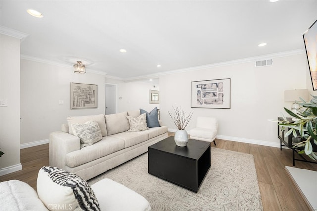 living room with baseboards, visible vents, and wood finished floors