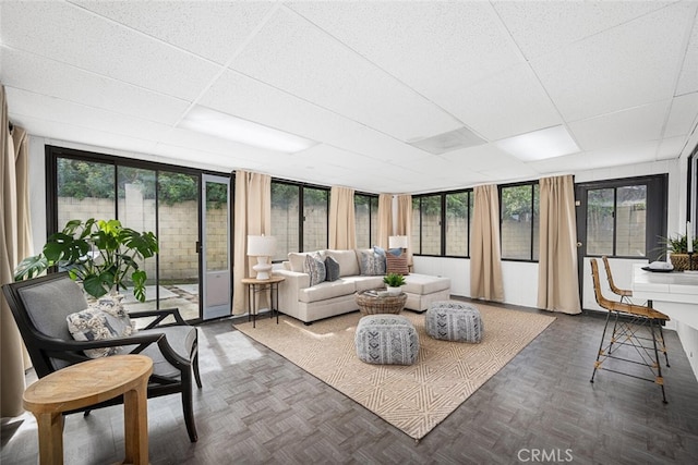 sunroom with a paneled ceiling and plenty of natural light