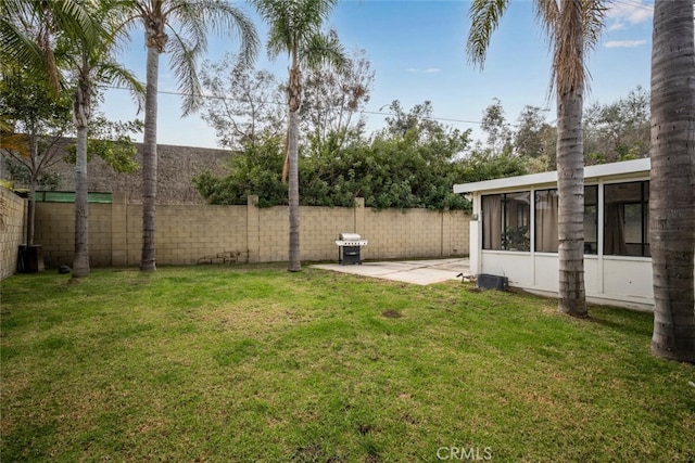 view of yard with a sunroom, a fenced backyard, and a patio area