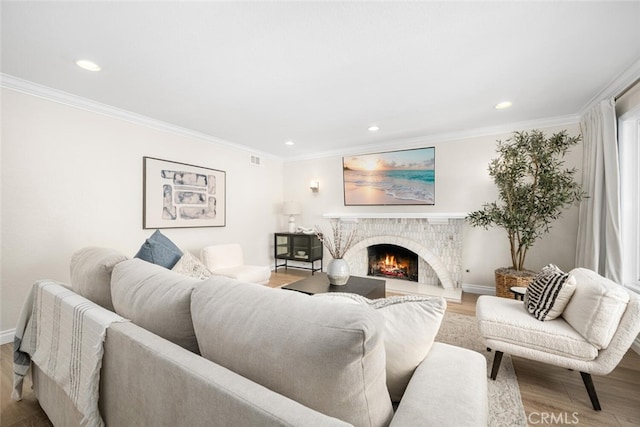 living room featuring recessed lighting, wood finished floors, ornamental molding, a brick fireplace, and baseboards