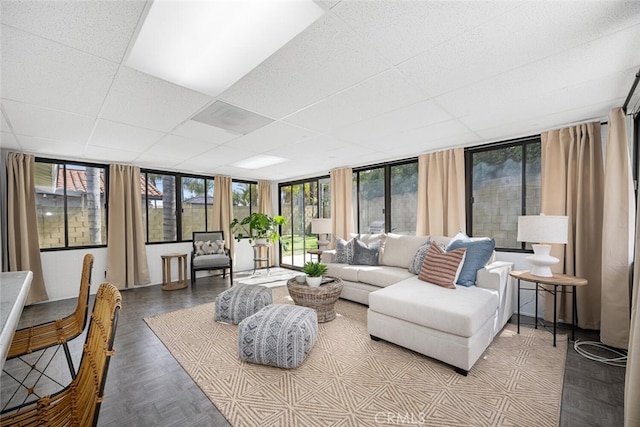 living area featuring a drop ceiling and plenty of natural light