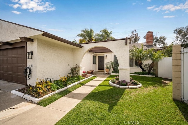 view of front of house with a garage, a front yard, and stucco siding