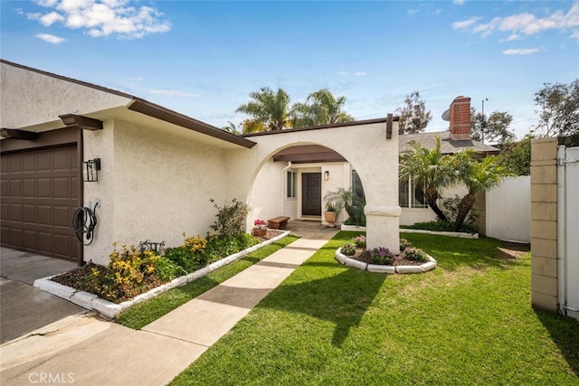 view of front of house with a front lawn, a garage, concrete driveway, stucco siding, and fence