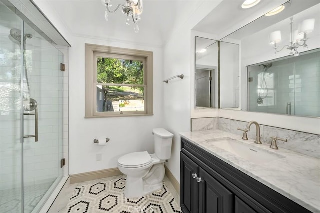 full bath with toilet, a shower stall, a notable chandelier, and vanity