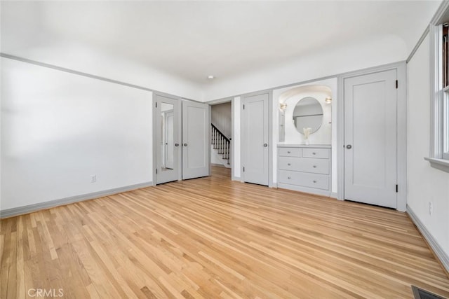 unfurnished bedroom featuring visible vents, baseboards, and light wood-style floors