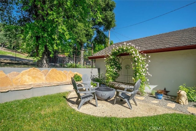 view of yard featuring an outdoor fire pit, a patio, and fence