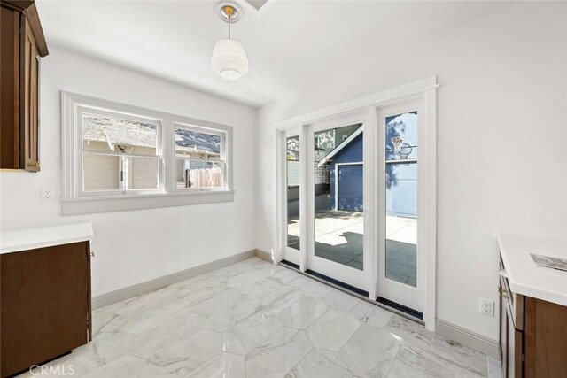 doorway with baseboards and marble finish floor