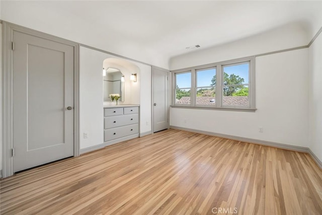 unfurnished bedroom with visible vents, baseboards, and light wood-style flooring