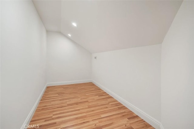 bonus room featuring vaulted ceiling, light wood-style floors, and baseboards