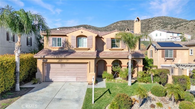 mediterranean / spanish-style house with stucco siding, a mountain view, driveway, and a tile roof