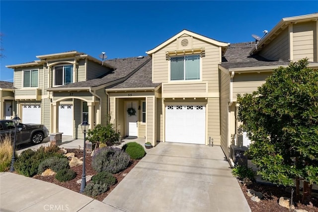 view of front of property with roof with shingles, driveway, and an attached garage