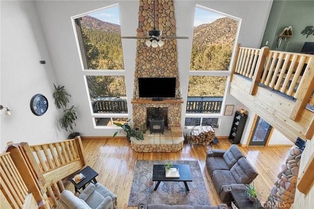 living room with a wealth of natural light, a wood stove, and a high ceiling