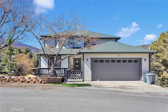 traditional home with a garage, covered porch, roof with shingles, and concrete driveway