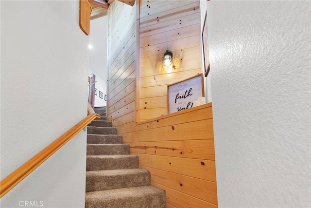 stairs with a textured wall and wooden walls