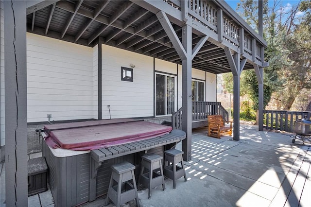 view of patio / terrace featuring a hot tub and a deck