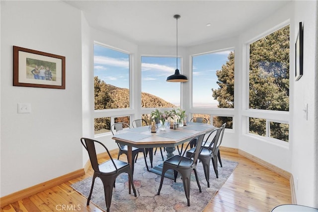 dining space with light wood-style flooring and baseboards