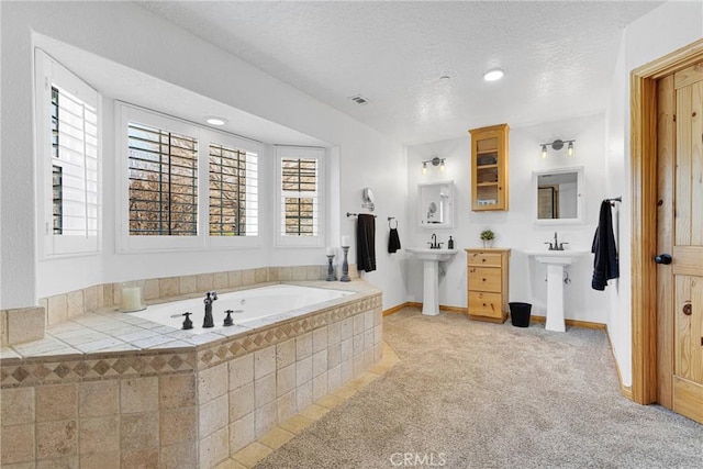 full bathroom with a bath, baseboards, visible vents, and a textured ceiling