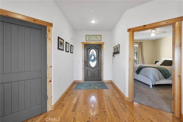 foyer entrance with light wood-style flooring and baseboards