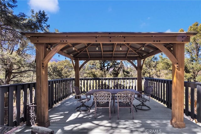 deck with outdoor dining area and a gazebo