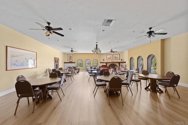 dining space featuring light wood-style floors, visible vents, and baseboards