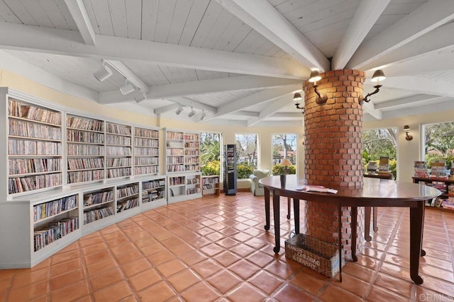 interior space featuring tile patterned floors, beamed ceiling, wooden ceiling, and wall of books