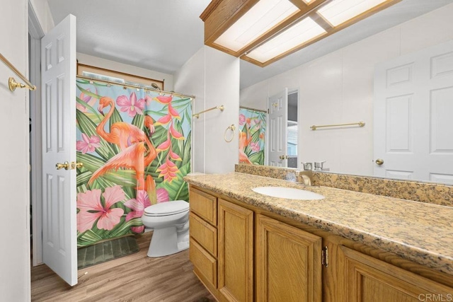 full bathroom with toilet, curtained shower, vanity, and wood finished floors