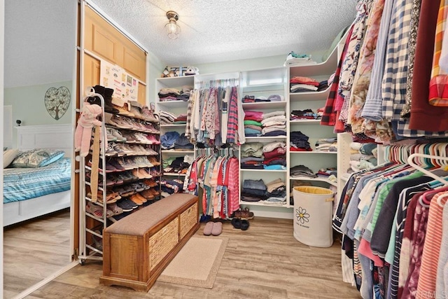 walk in closet with wood finished floors