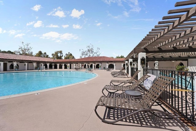 community pool with a patio, fence, and a pergola