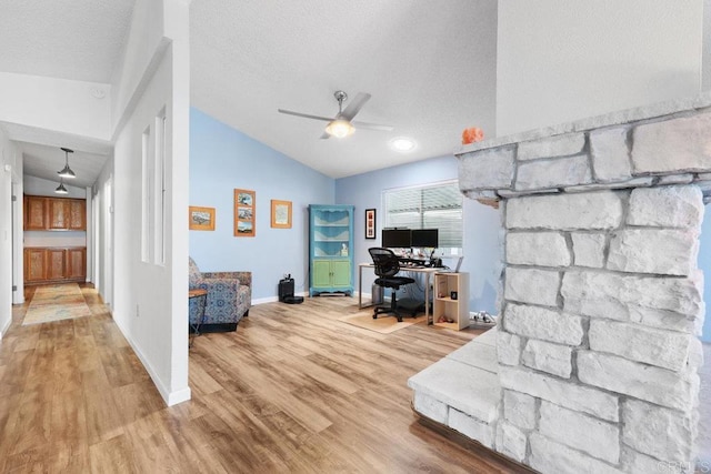 office with vaulted ceiling, a textured ceiling, baseboards, and wood finished floors