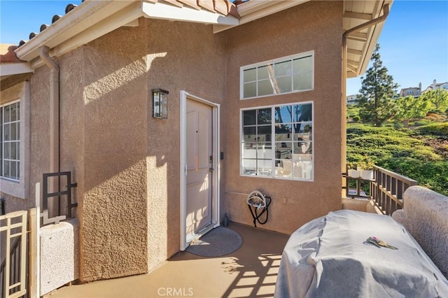 view of exterior entry featuring stucco siding