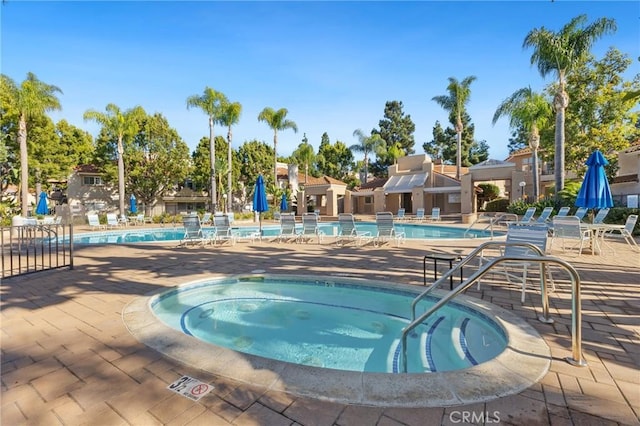 community pool featuring a community hot tub and a patio